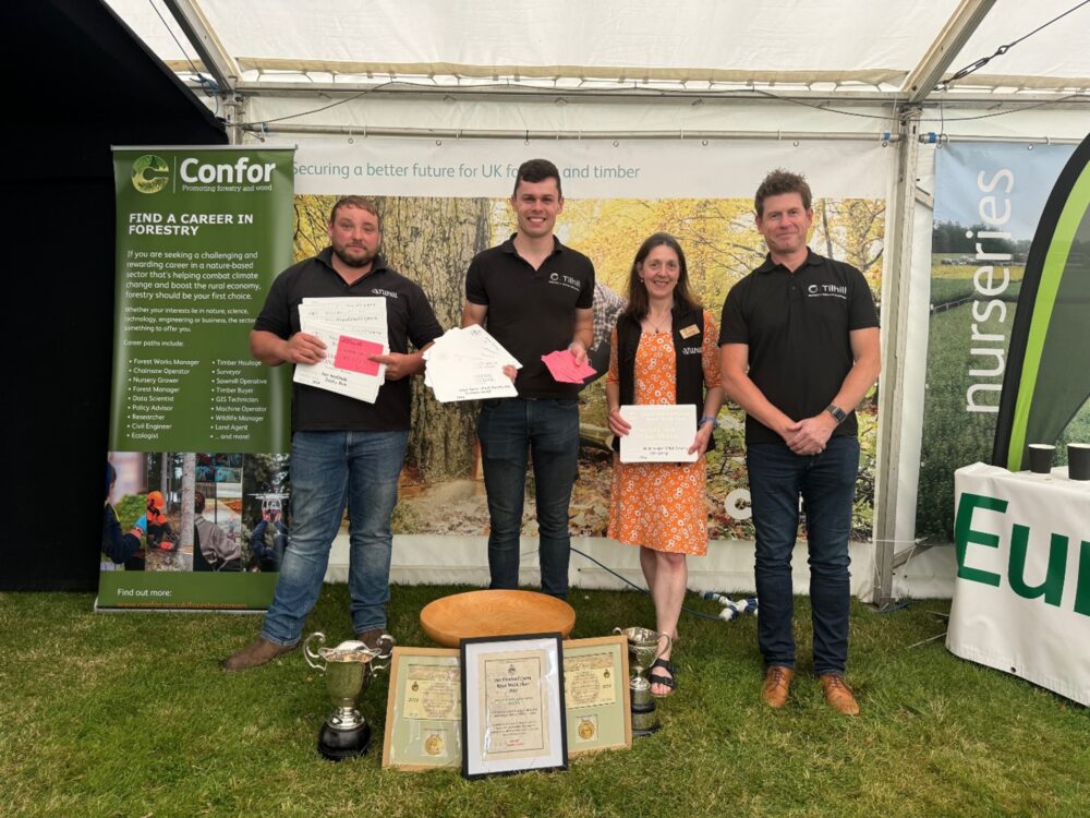 4 members of the Tilhill Forestry team stand in a line holding the awards they have won.